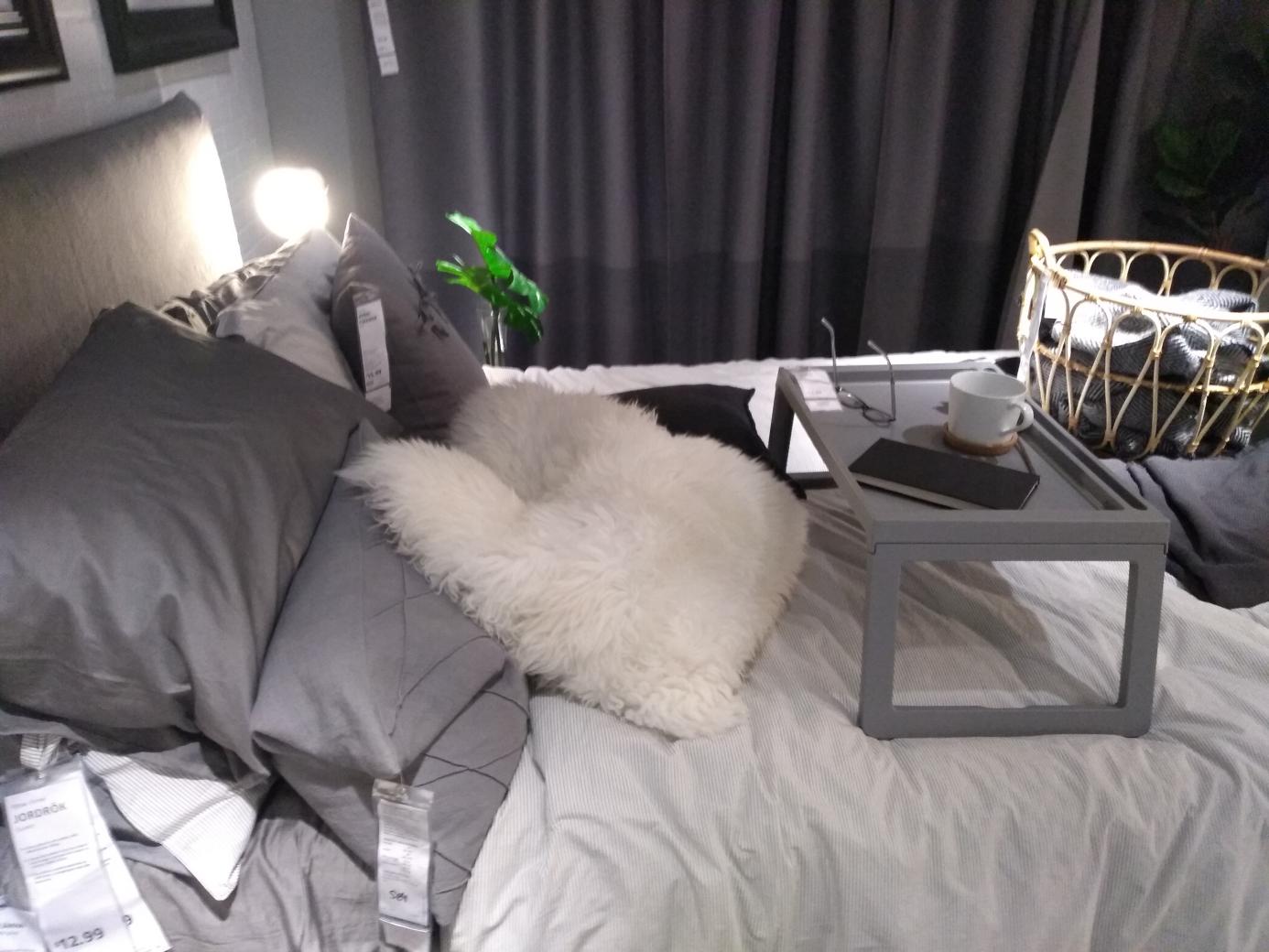 A bedroom display with a pair of glasses on a tray.