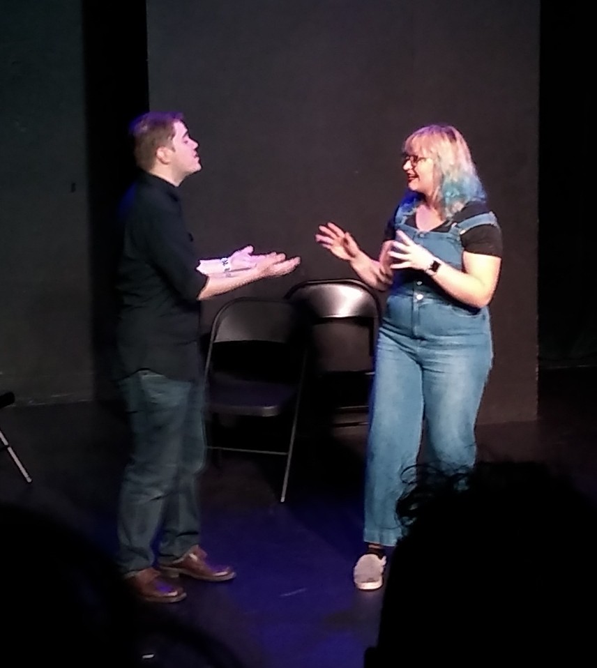 A man and a woman facing each other and talking.