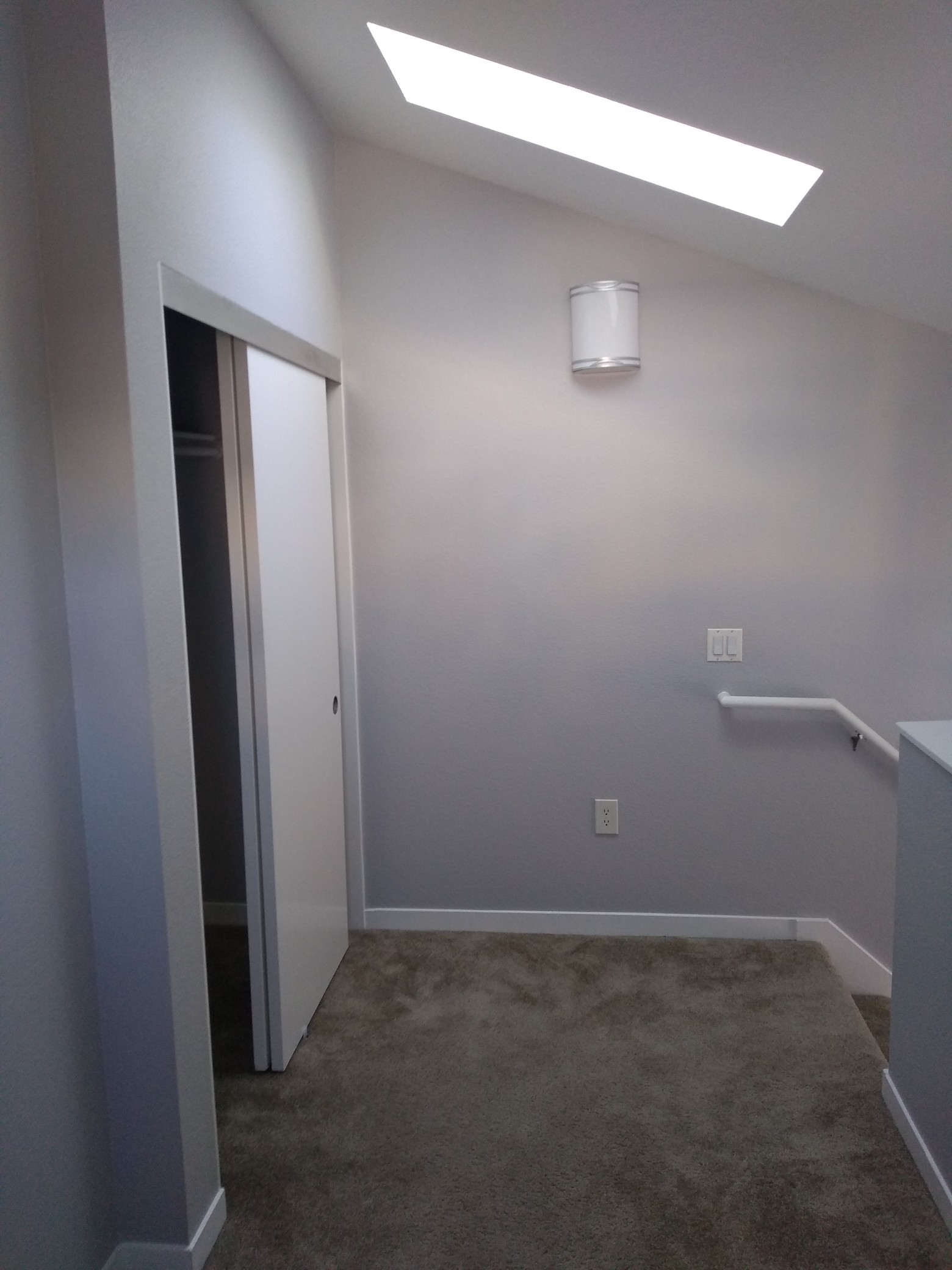 View of the loft, showing the skylight, closet, and stairs.