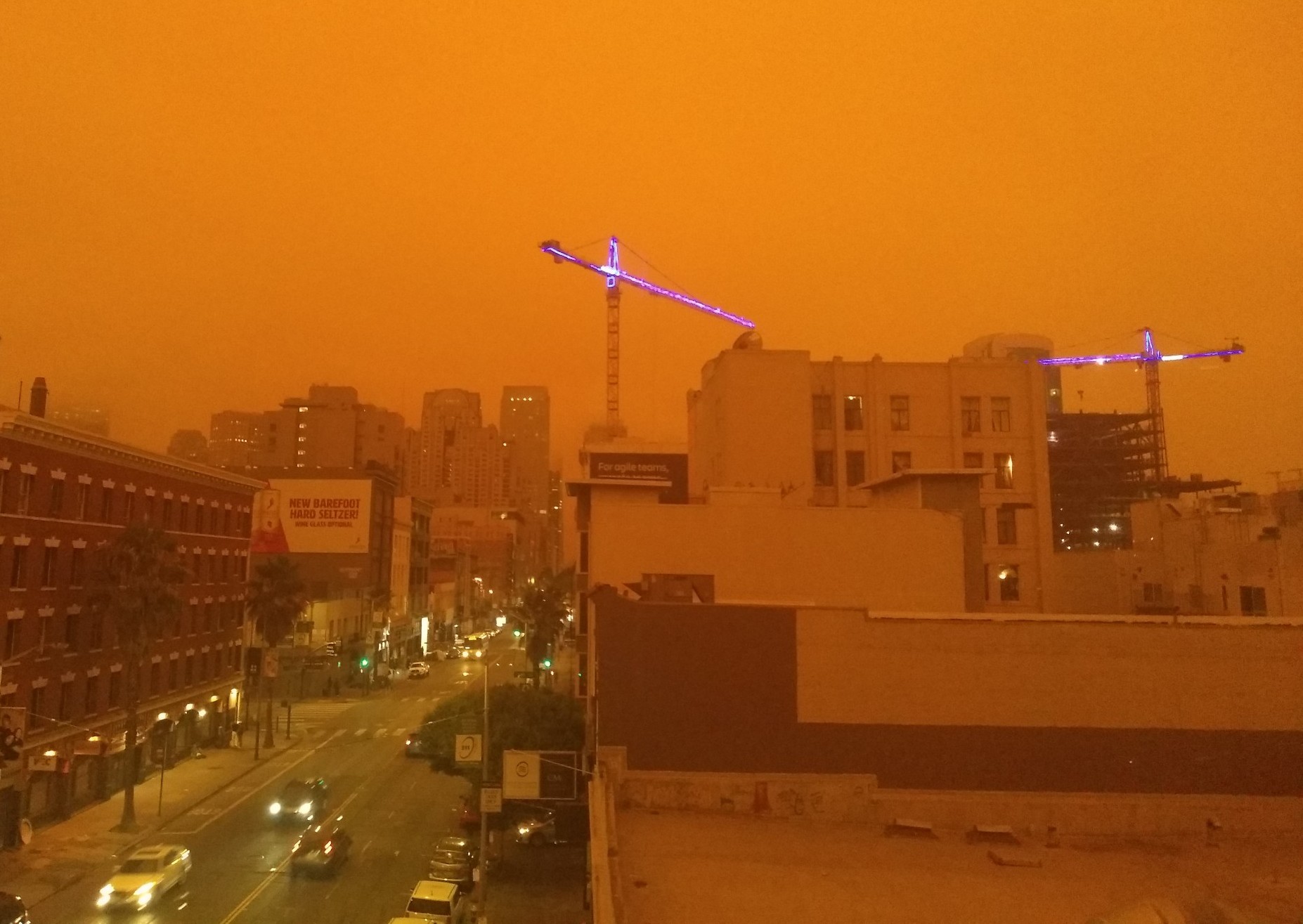 A rather dim picture of the San Francisco skyline, with a vivid orange cast over everything. The brightest thing in the photo is car headlights.
